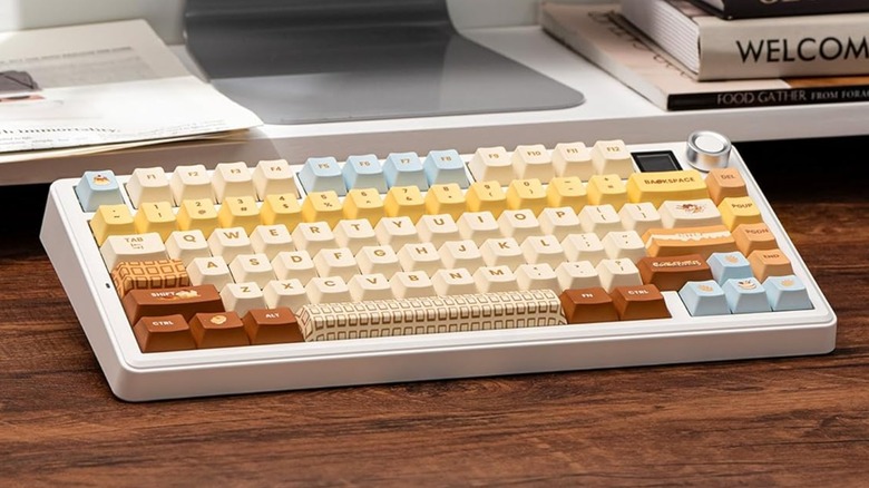 A Epomaker X Aula F75 MAX Wireless Mechanical Keyboard sits on a wooden desk, there are some papers and books behind it