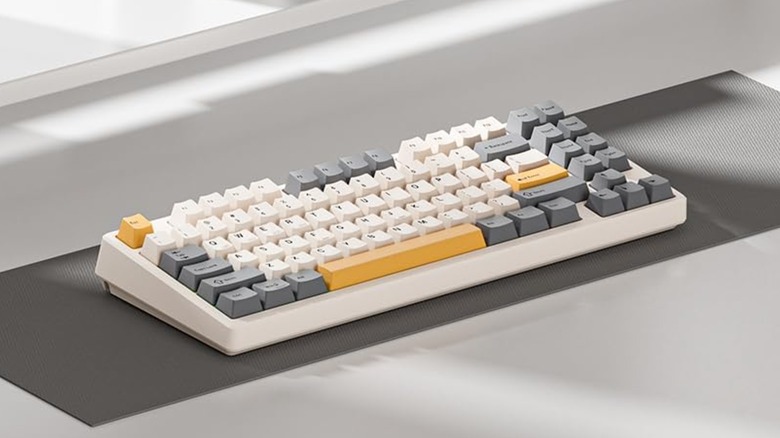 A closeup of the Kisnt KN85 Wireless Mechanical 75% Gaming Keyboard, showcasing the keycaps' yellow, grey, and white design