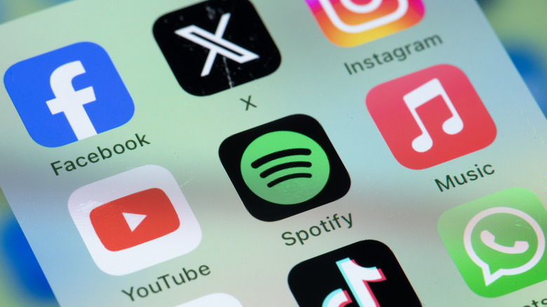 apple music icon next to spotify icon and other apps on a smartphone display