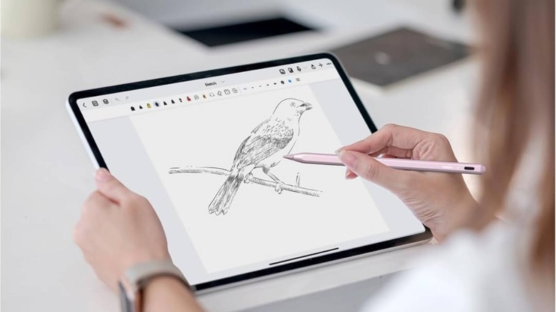 A person using the Metapen Pencil A8 with a large iPad on a drawing table