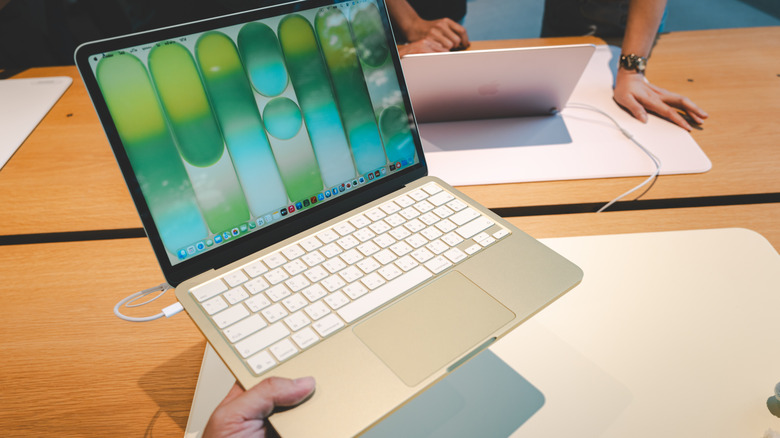 A group of customers explore and test the features of the new MacBook Neo at Apple Store.