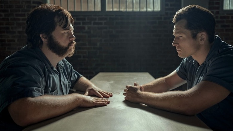 Hall and Keene facing each other at a table in prison