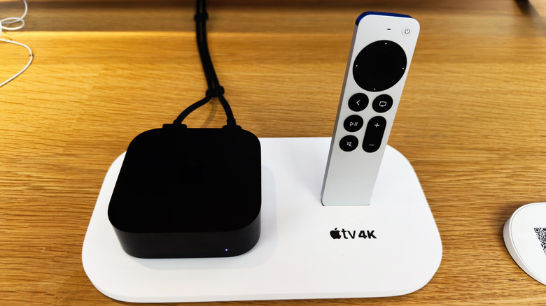 Apple TV and its remote placed on a table