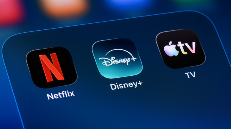 Close up of a phone and the Netflix, Disney+, and Apple TV app icons.