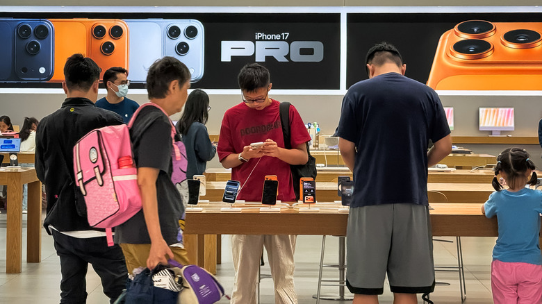 Consumers looking at the iPhone 17 models in an Apple retail store.