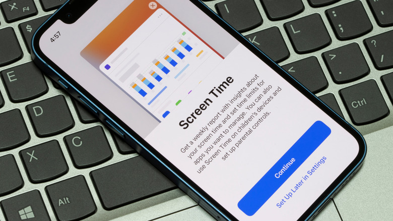 iPhone showing screen time setup screen while the device sits on top of a macbook keyboard