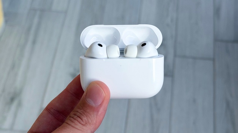 A hand holding AirPods Pro 3 inside the charging case