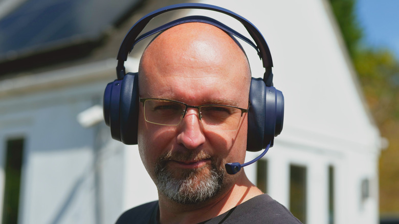 Reviewer James Bruce wearing the Arctis Pro Omni headphones outside, face toward the camera