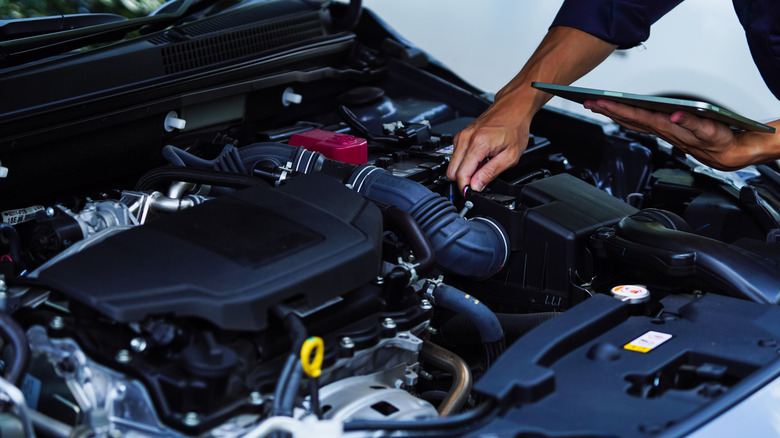 a mechanic looking at a car engine