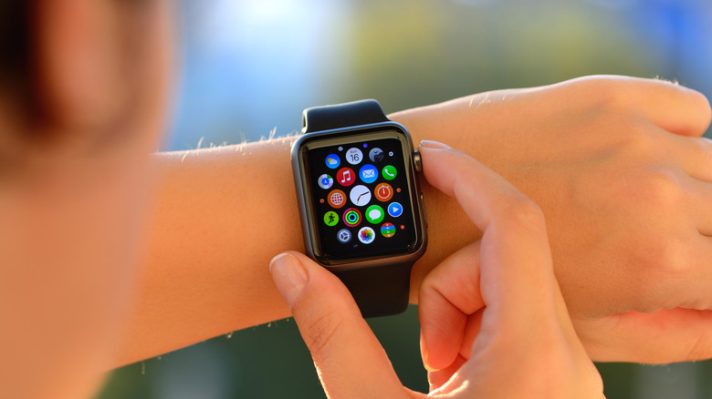 A closeup of someone engaging the Digital Crown on their Apple Watch on a sunny day