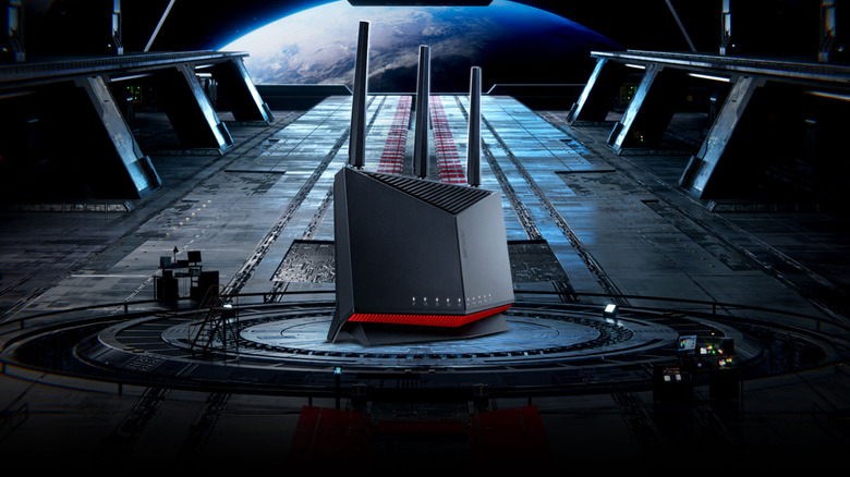 A black Asus gaming router with three antennas and a red accent strip.