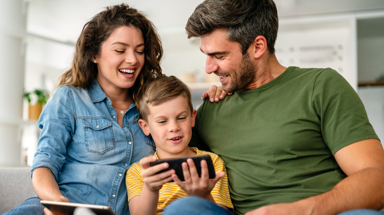 Family sitting on the couch browsing the internet on their phones