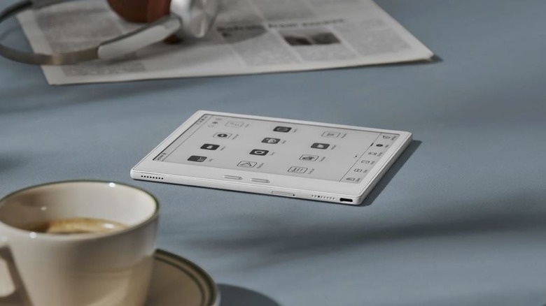 A Boox Go e-reader on a table with coffee nearby.