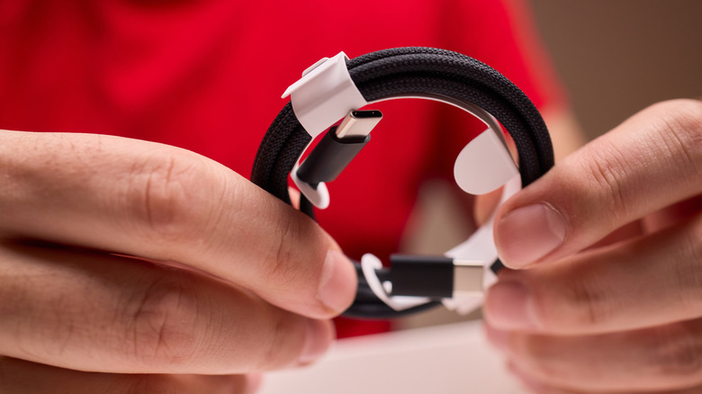 Person holding a coiled up and braided USB-C cable