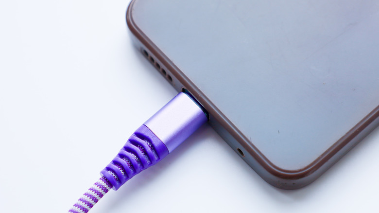 braided USB-C cable plugged into a smartphone, charging it
