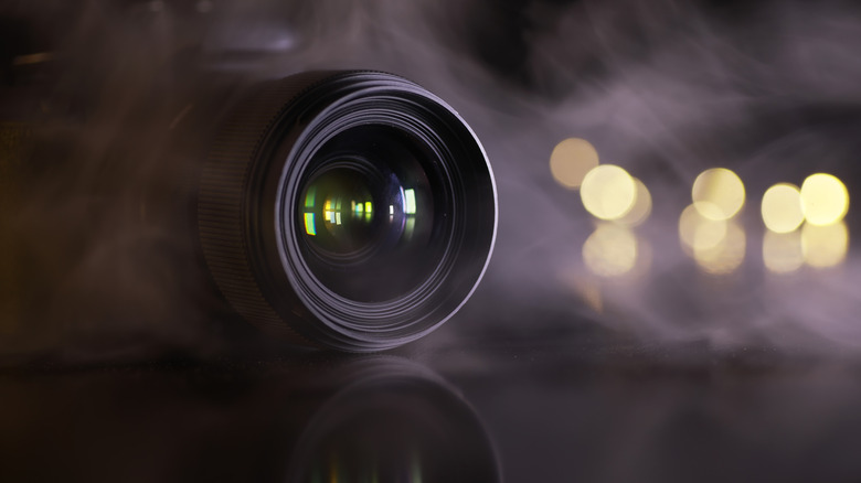 Close-up of camera lens surrounded by fog