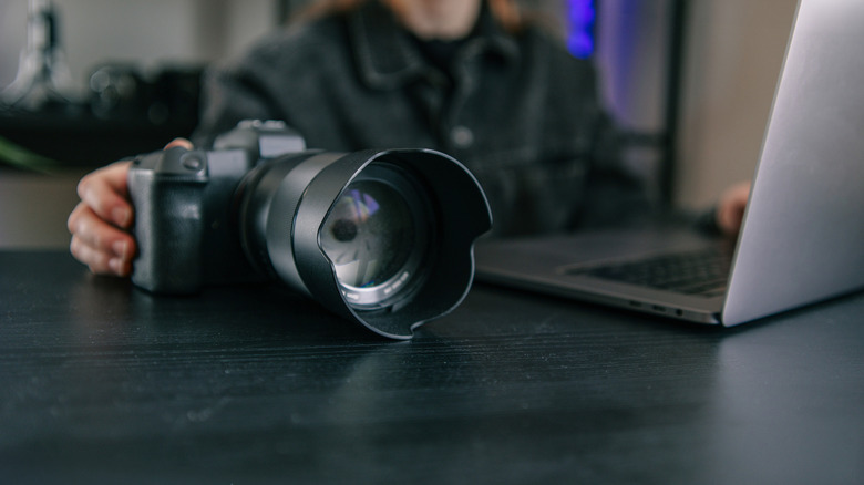 Image showing a large DSLR camera next to a laptop computer.