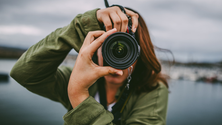 Young woman using a large DSLR camera.