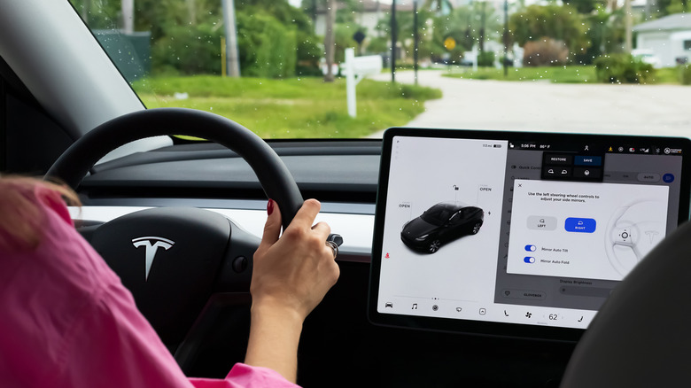 Hands on the steering wheel of a Tesla car
