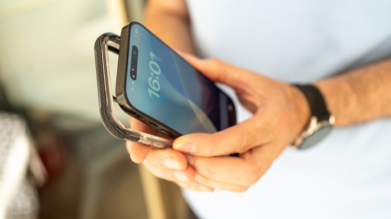 A man's hands putting a case on a phone.