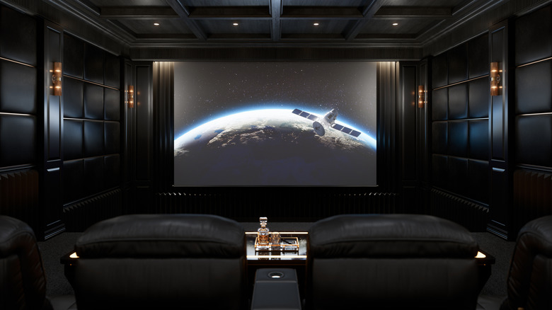 a home theater with a black interior and a projector screen
