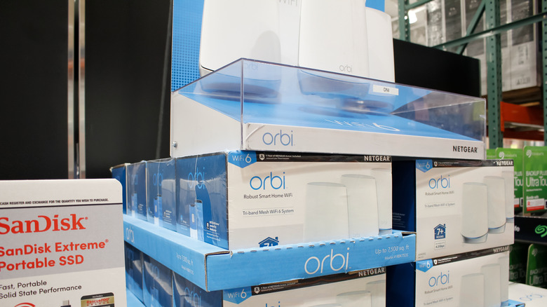 Netgear Orbi mesh Wi-Fi routers stacked in a retail store.