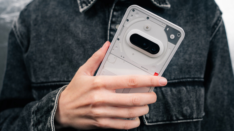 Nothing Phone 3a held in someone's hand with the transparent back visible.