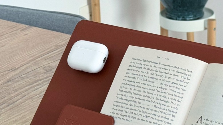 AirPods Pro 2 charging case alongside a book