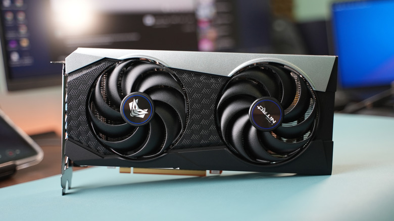An AMD RX 6000 series graphics card from Sapphire sitting upright on a desk
