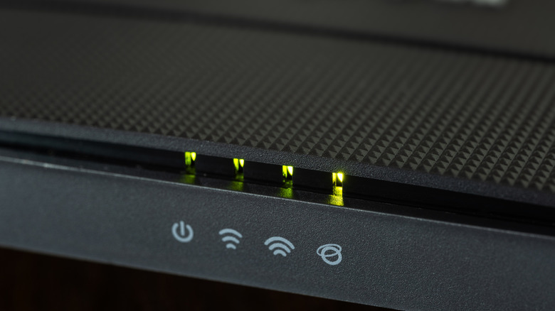 Close up of the status indicators and LED lights on the front of a wireless router.