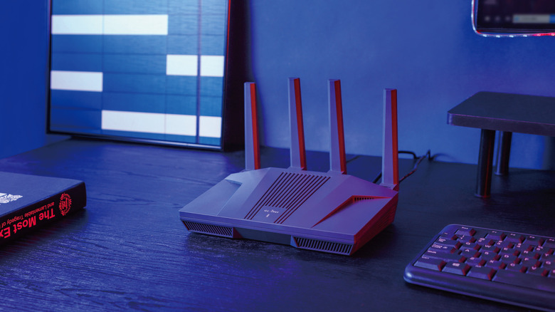 GL.iNet Flint 2 wireless router on office desk with neon lighting.