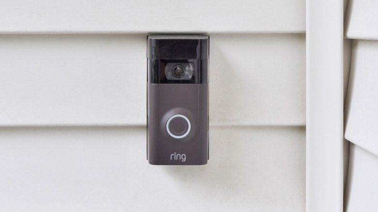 A Ring doorbell camera installed on the siding of a home.