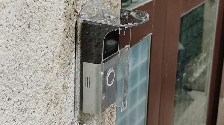 A transparent Ring video doorbell cover from Dgyezhao installed on along with a Ring video doorbell.