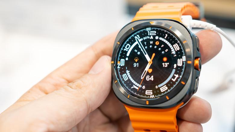 A hand holding the Samsung Galaxy Watch Ultra.