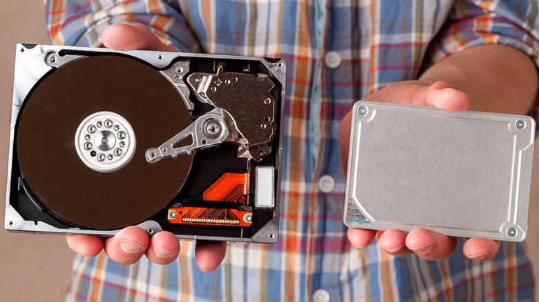 Someone holding a HDD and a SSD side-by-side.
