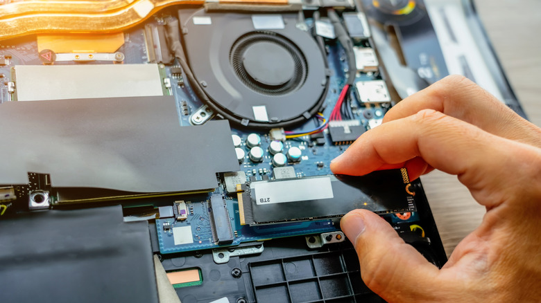 A person connecting an SSD to a motherboard