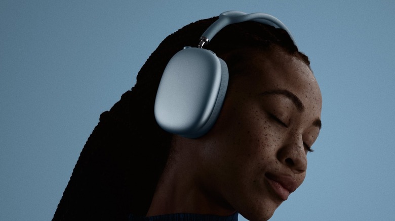 Woman wearing AirPods Max 2 in a blue background