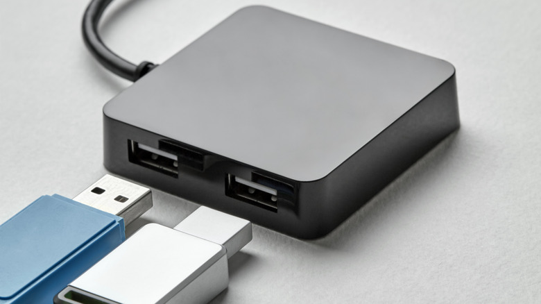 A black USB Hub on a white desk with two USB-A ports.