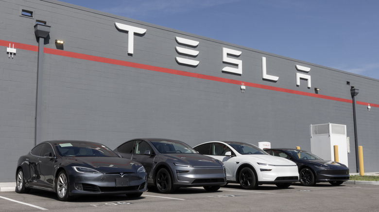 Tesla vehicles in a Tesla repair shop parking lot