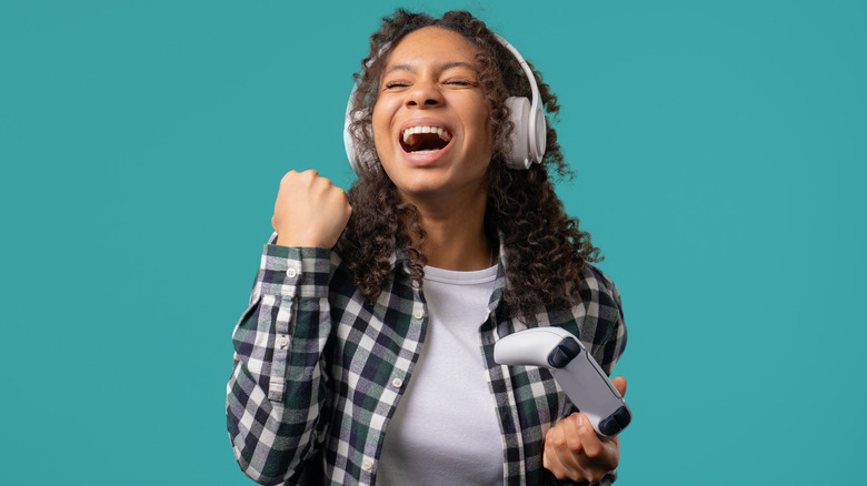 A gamer using wireless headphones and a wireless controller