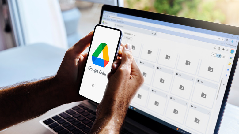 A person holding a phone with the Google Drive app opening up