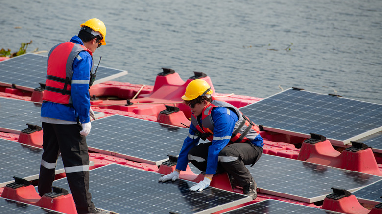 Workers adjusting floating solar panels