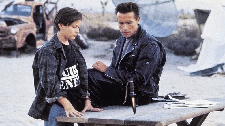 Young John Connor and The Terminator looking at a knife