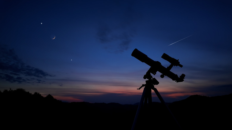 telescope with night sky backdrop, concept of astronomers looking at sky