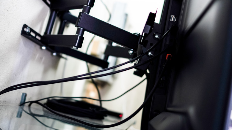 Several cables attached to a wall-mounted TV.