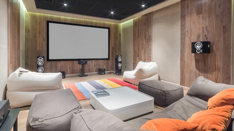 A home theater setup that includes a TV, multiple speakers, and multiple floor cushions around a coffee table.