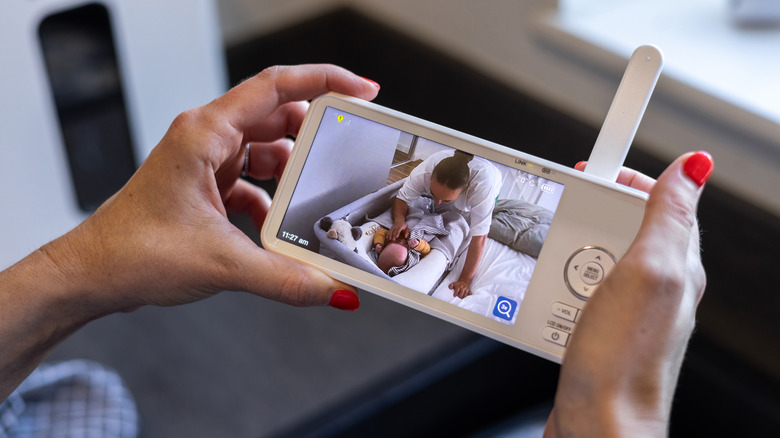 A person looking at their baby through a baby monitor.
