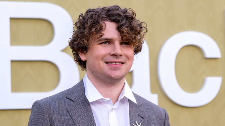 A photo of YouTuber Kane Parsons in a grey suit at the A24 premiere of the horror film 