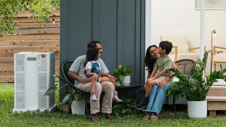 Family outside with Base Power battery backup in view.