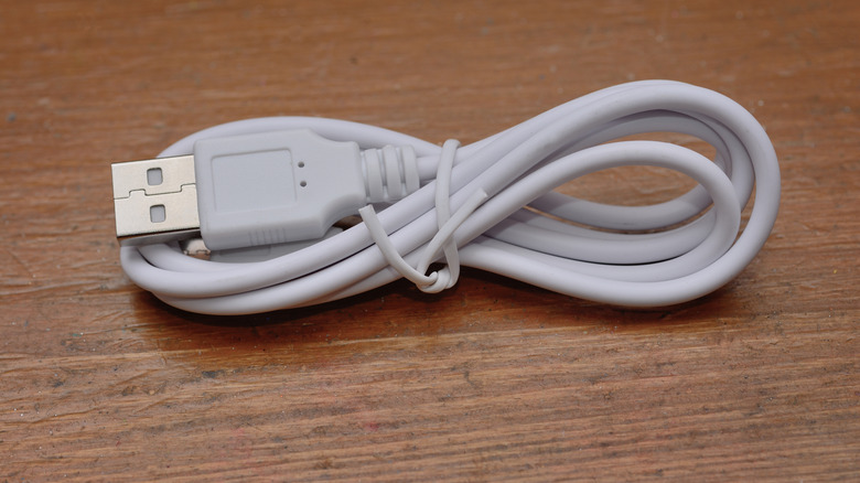 Smartphone USB charging cable on wooden surface